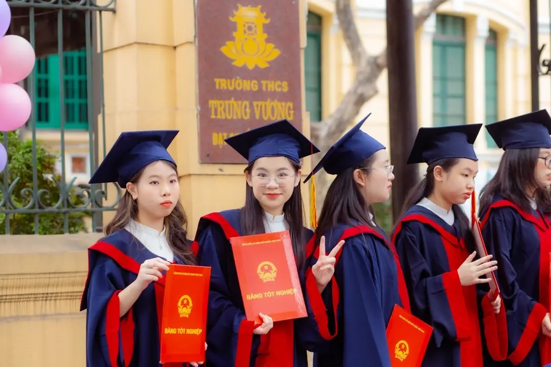 Graduates in gowns holding their diplomas